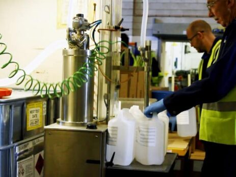 Workers filling containers of chemicals