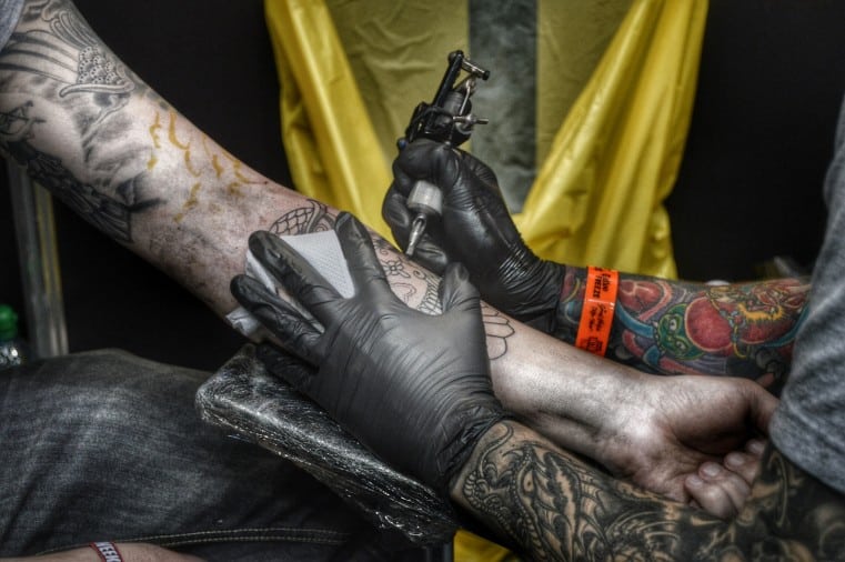 A person getting a tattoo on the inside of his forearm