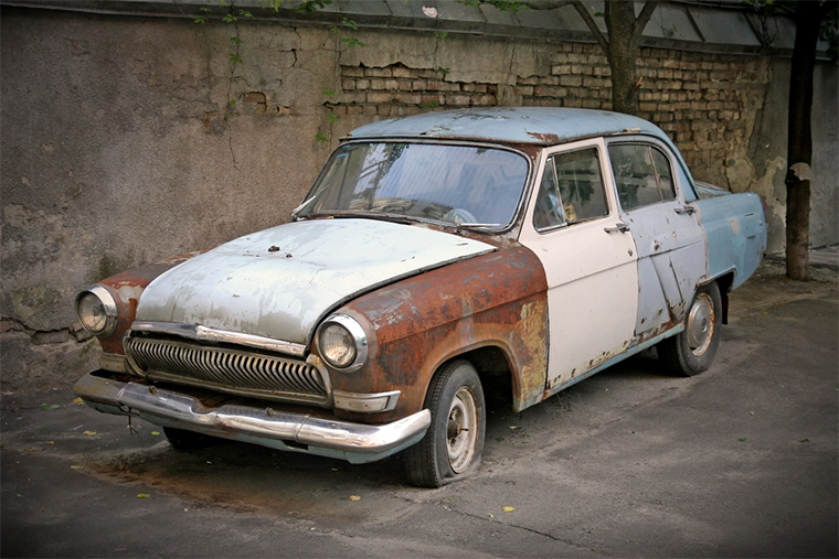 A side view of a rusty car, which is caused by oxidation