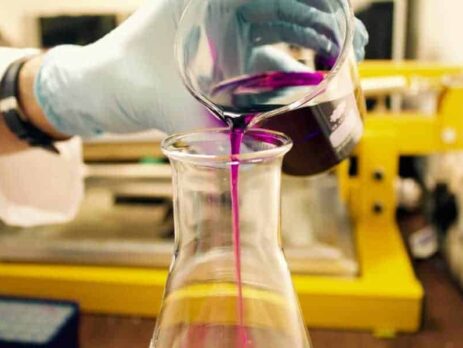 Pouring purple liquid from one beaker into another