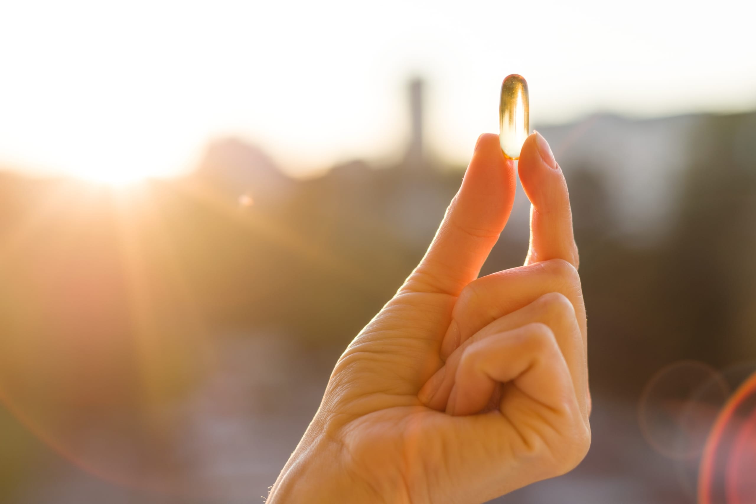 Hand holding a vitamin D tablet