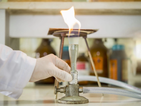 Scientist adjusting a Bunsen burner in a chemistry lab.||Red striped poison dart frog||A scientist wearing PPE to conduct an experiment in a chemistry laboratory||Image warning workers to wash their body following exposure to chemicals