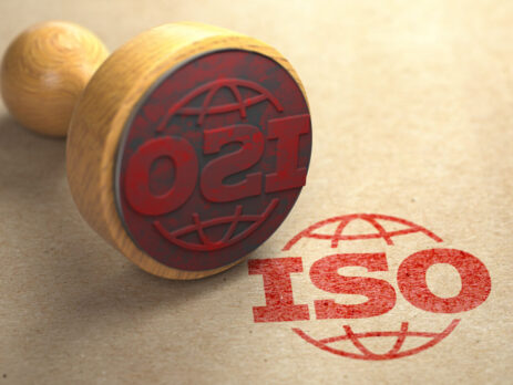 3D illustration of a rubber stamp with the text ISO 9001 on a paper background