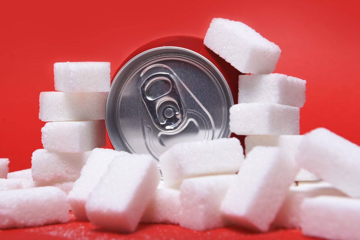 Can of cola surrounded by white sugar cubes