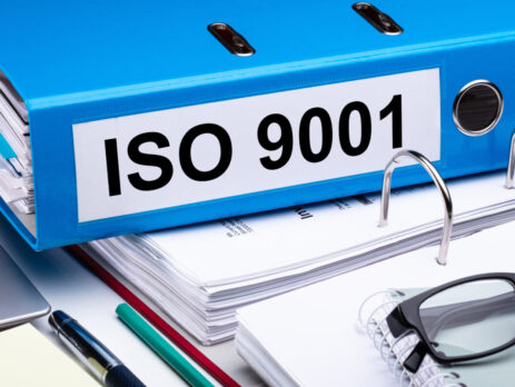 Documents and a blue folder labelled with ISO 9001