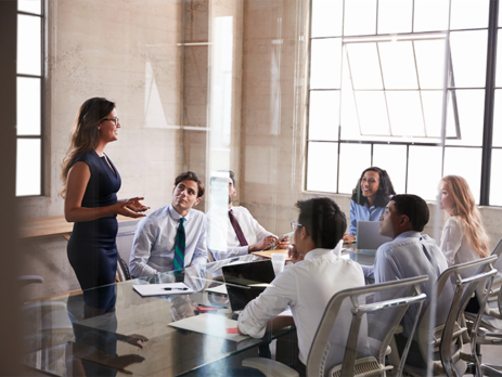 Office workers having a meeting around a table by a large window