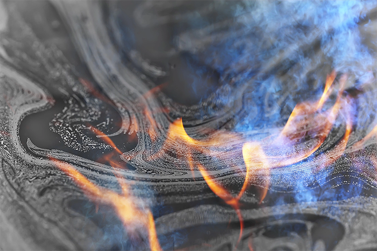 Close up of an oil spill with fire burning on it