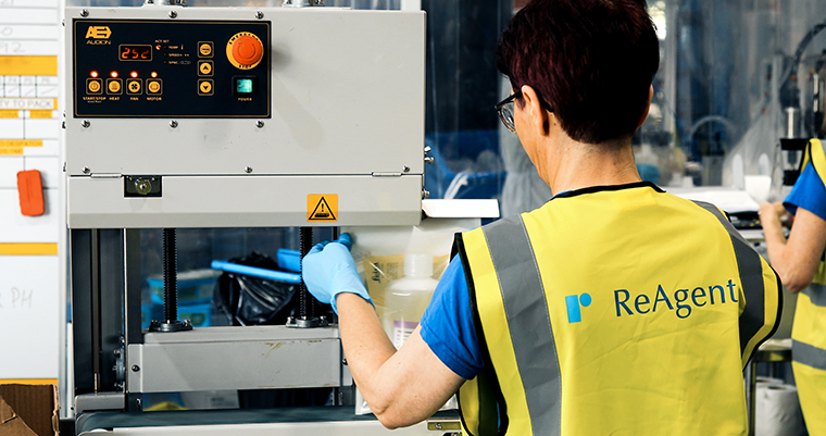 A ReAgent employee using a packaging sealing machine