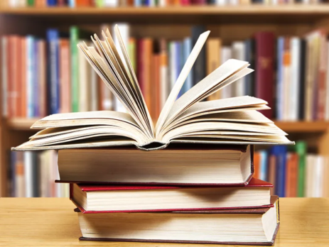 Pile of books on a table in a library