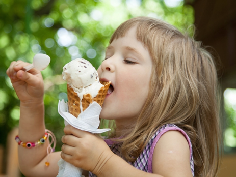 Young girl licking an ice cream cone