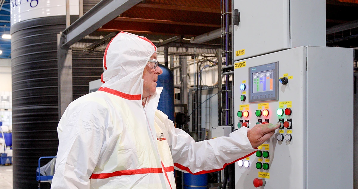 ReAgent worker pushing buttons to operate a large fume extraction booth