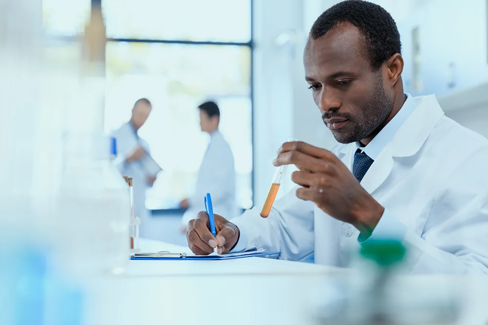 Scientist in a lab looking at a test tube containing a reagent 