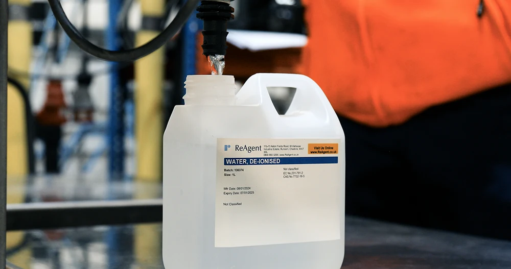 De-ionised water in a white jug being produced by Reagent in a factory setting. This is an example of purified water.