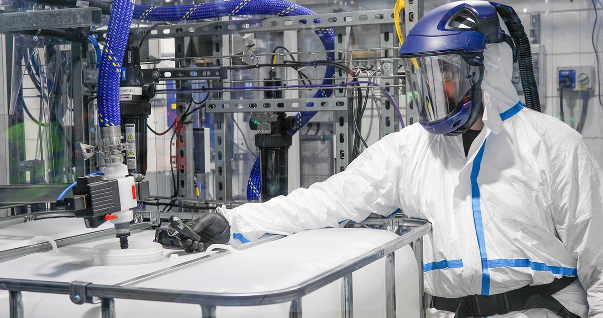 Worker wearing PPE testing chemicals in one of ReAgent's cleanrooms