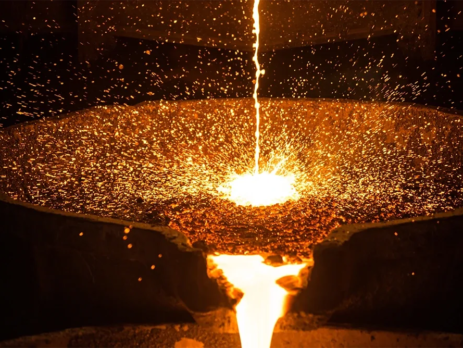 Steel smelted down in a crucible is poured out, an example of metallurgy