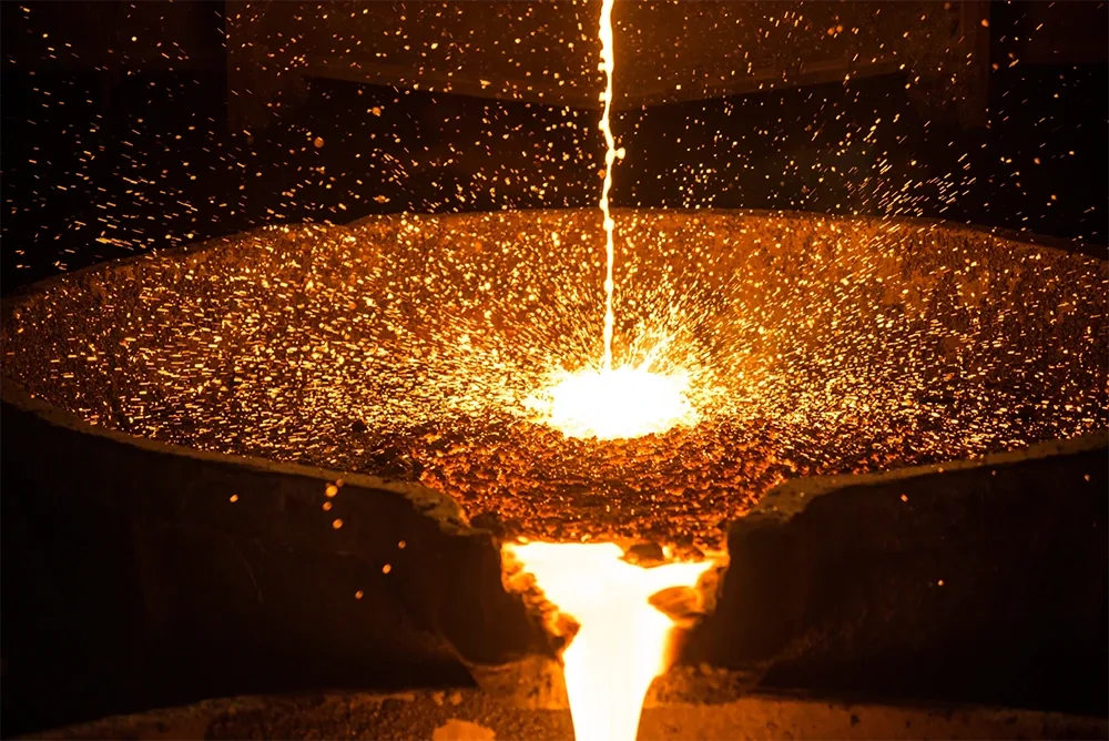 Steel smelted down in a crucible is poured out, an example of metallurgy