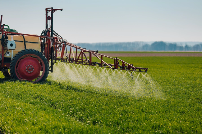 Tractor spraying herbicides on a field