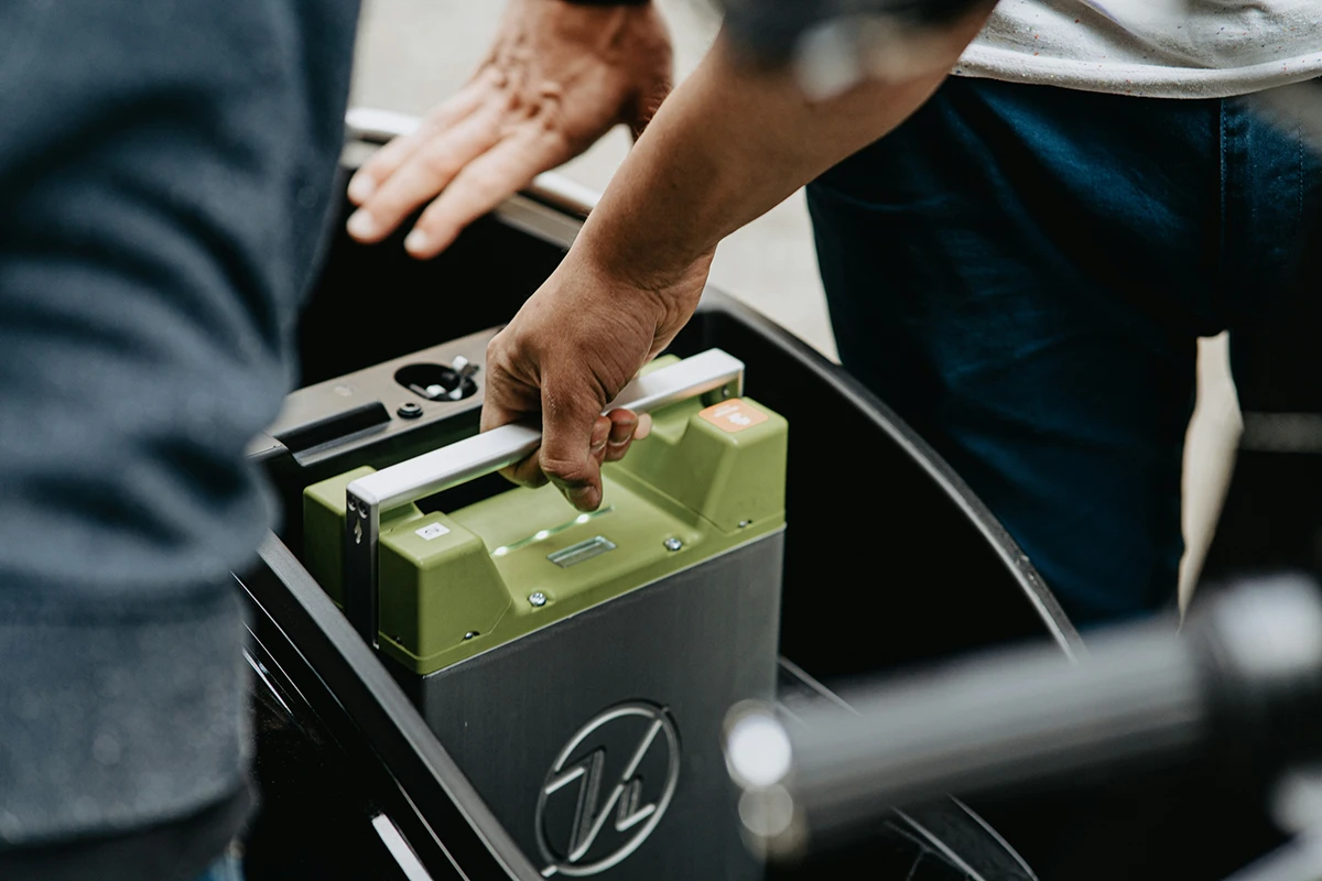A person replaces the lithium ion battery in their car.