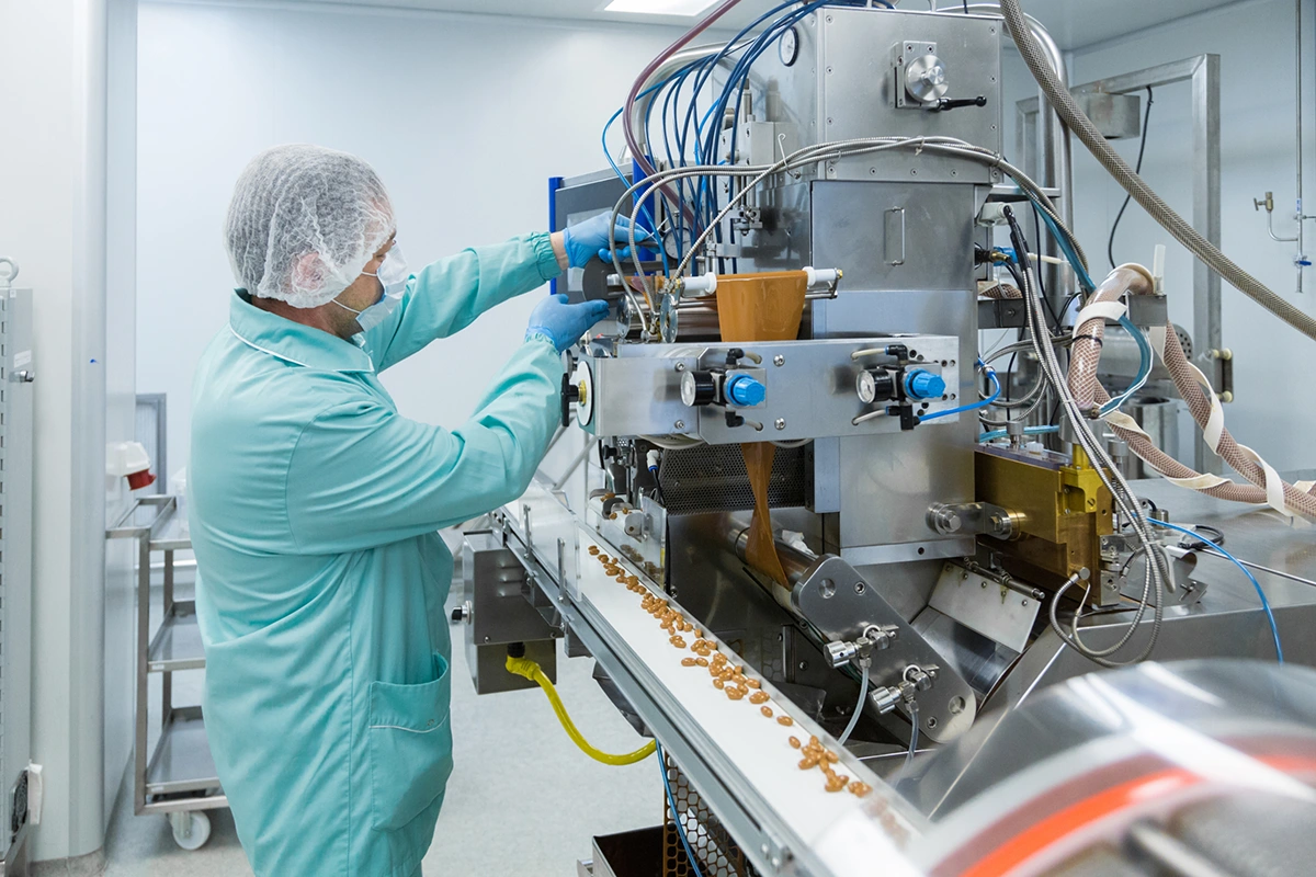 Man examining equipment used in pharmaceutical manufacturing
