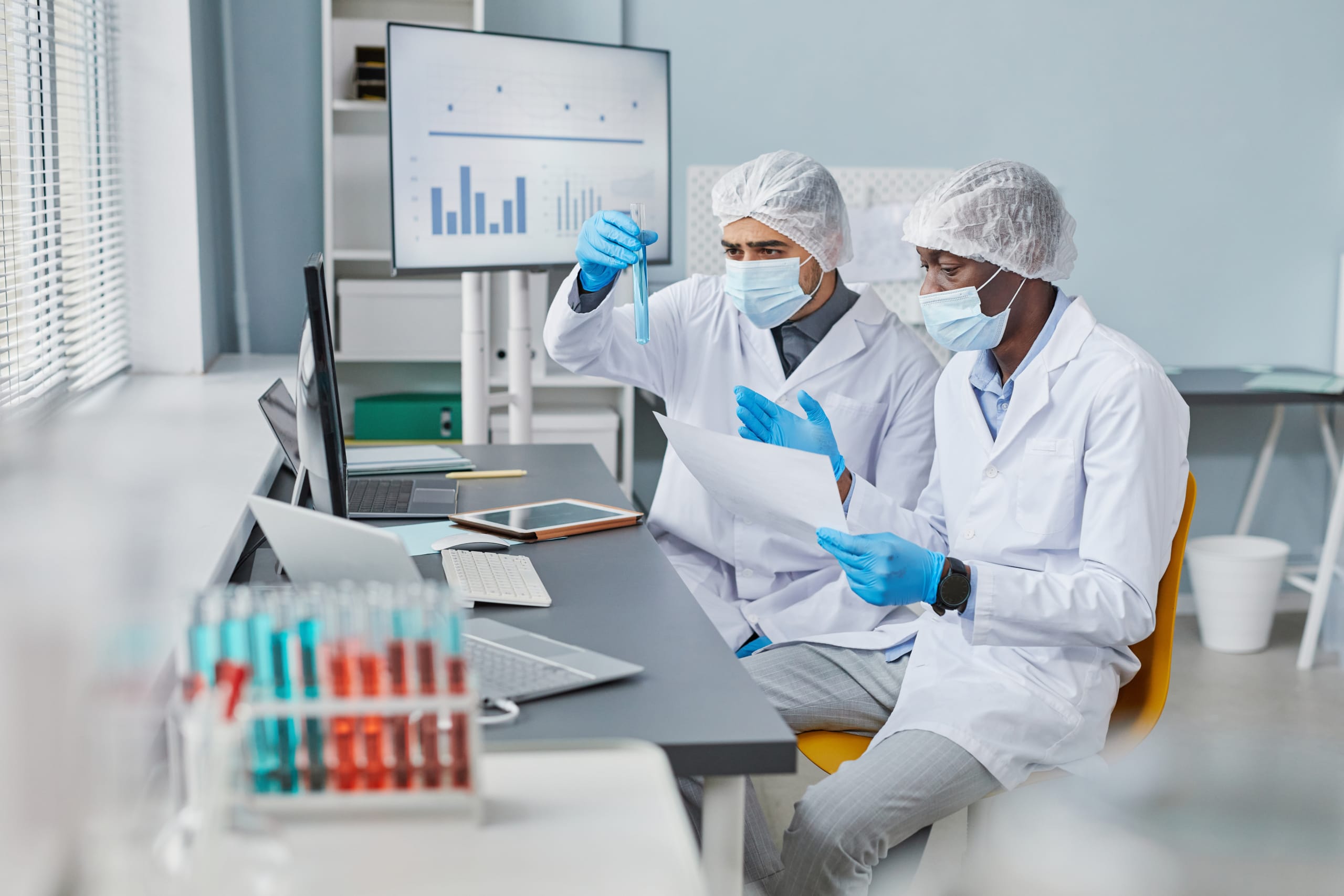 Scientists performing elemental analysis with test tubes in a lab