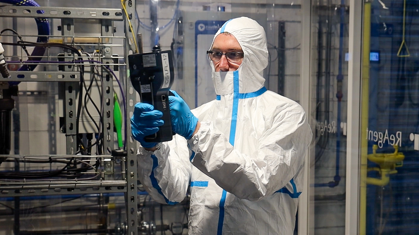 Technician in a cleanroom operating testing equipment