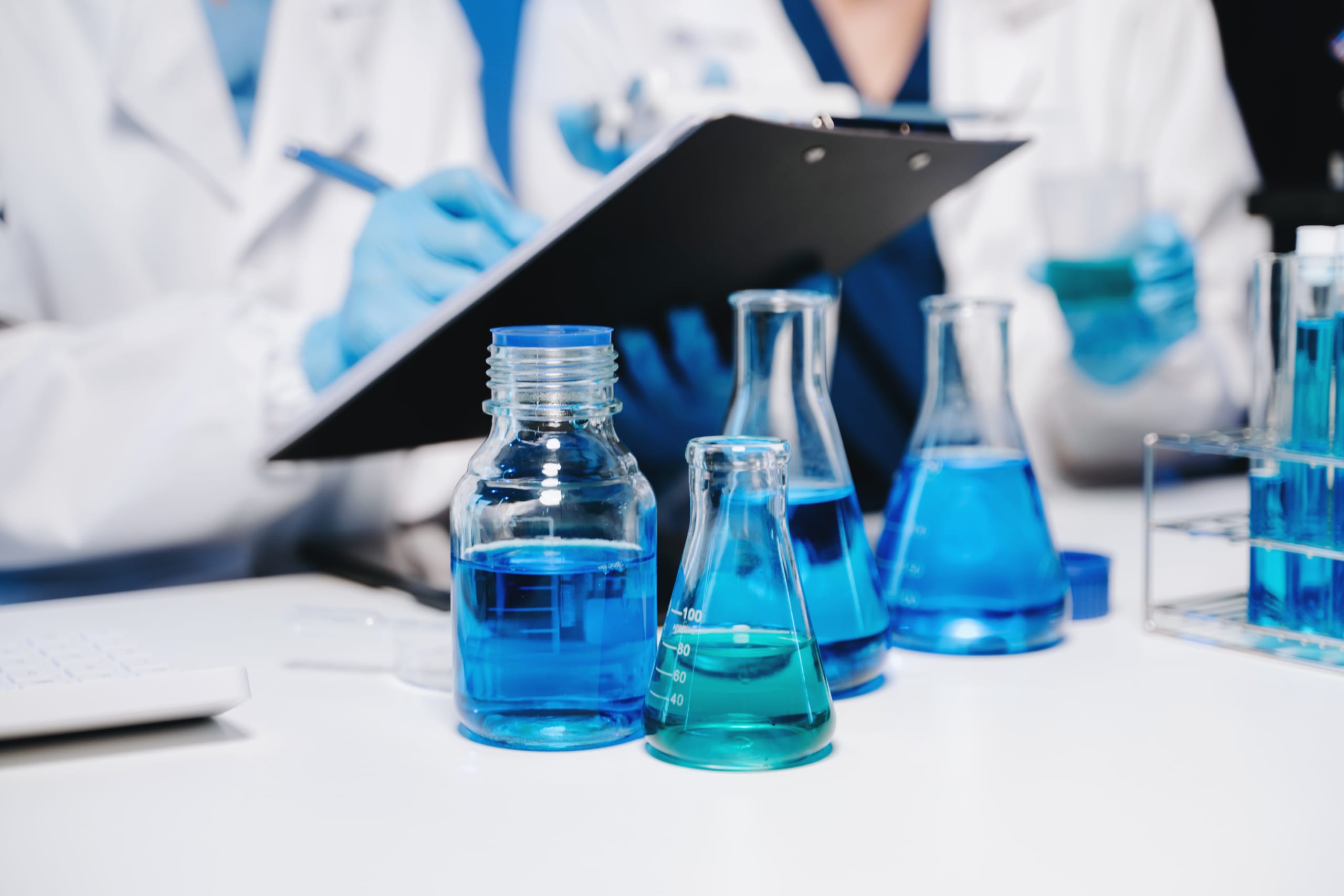 Two chemical lab technicians with a clipboard