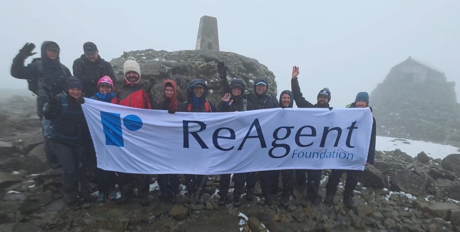 The team holding a ReAgent Foundation banner at the summit of Ben Nevis