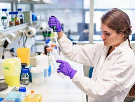 A woman in a laboratory carries out a redox reaction process.