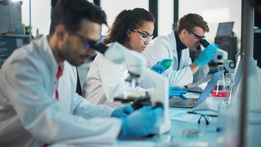 Chemistry students looking at microscopes in a lab