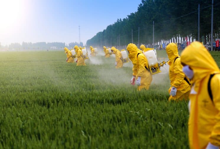 Farmers spraying pesticides on a field