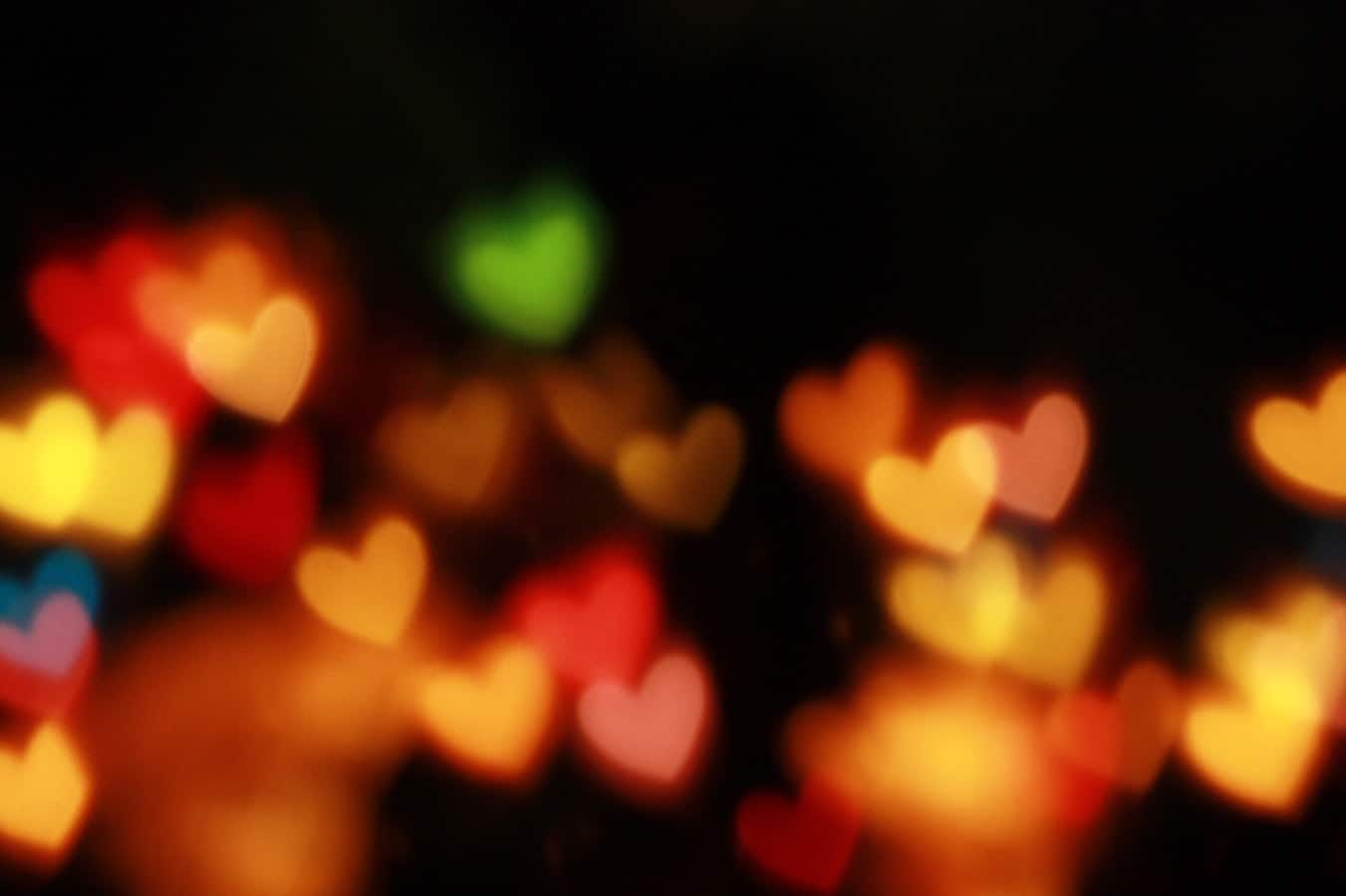 Love heart shaped lights glowing amber in the dark