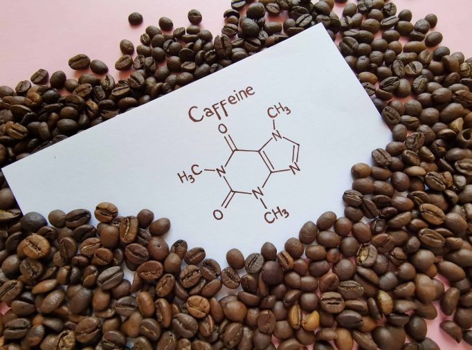 Structural chemical formula of caffeine molecule with roasted coffee beans