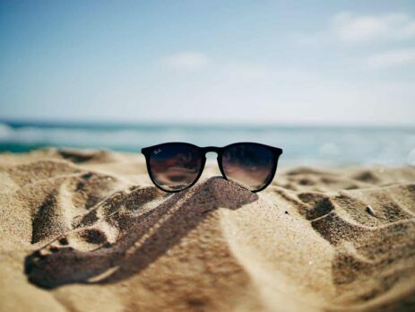 A pair of sunglasses on a mound of sand