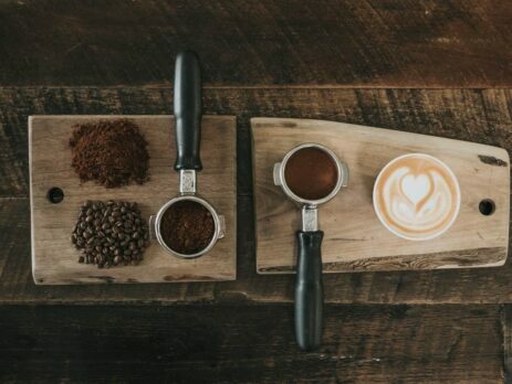 Coffee beans, ground coffee, and a cup of coffee on a table